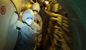 Officers walk past the submarine's nuclear reaction cabin